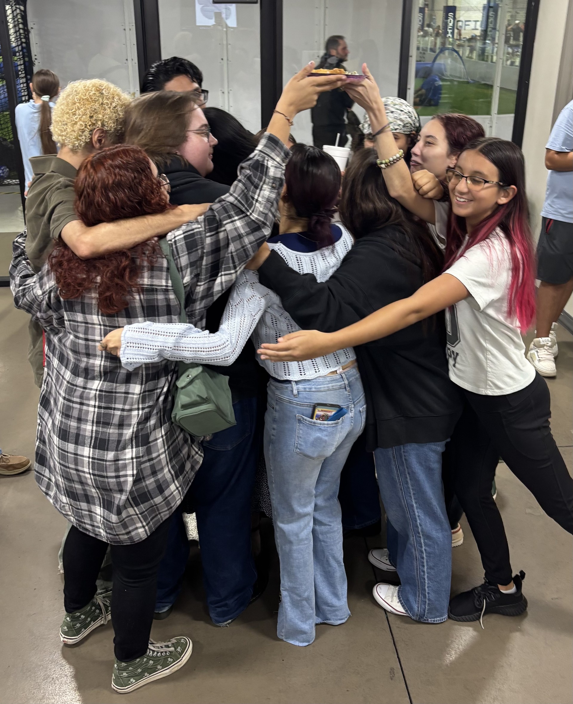 Teens embracing in a group hug at a Rebuild Yourself gathering